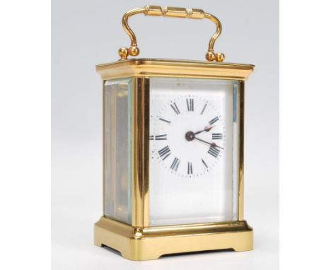 An early 20th century brass cased carriage clock&nbsp; having inset enamel face with roman numeral chapter ring and faceted h