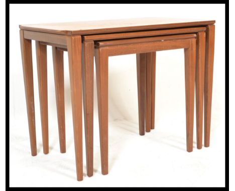A vintage retro 20th Century Danish teak nest of three nesting tables raised on tapering block legs with shaped tops.