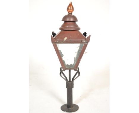 A 19th Century Victorian street light of copper construction with mottled glazed panels and finial top, raised on an ebonised