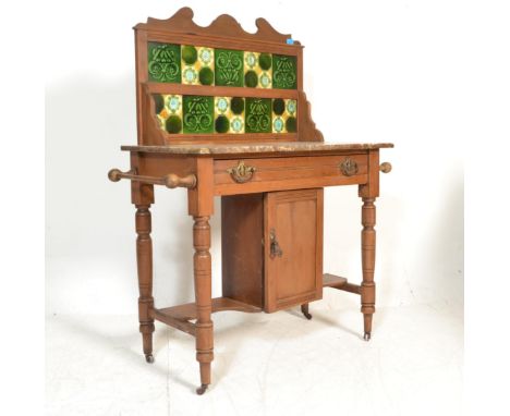 A 19th Century Victorian mahogany washstand having a marble top with majolica tiled splash back with twin handled drawer and 