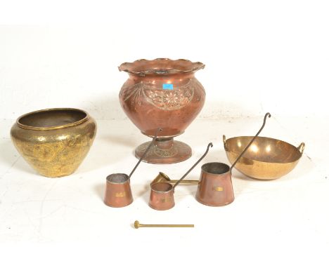 A late 19th / early 20th Century copper jardiniere planter raised on a round footed base with repousse floral garland decorat
