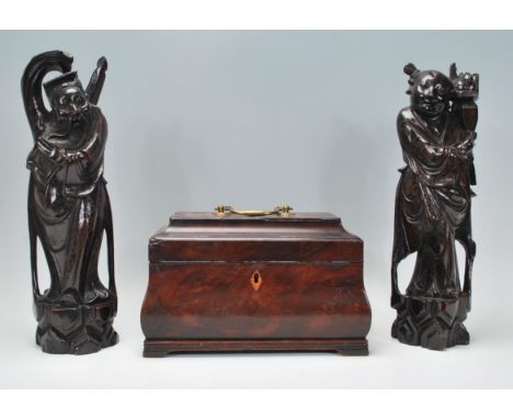 A pair of early 20th Century Japanese carved hardwood figurines of elders inlaid with silver wire standing on naturalistic pl