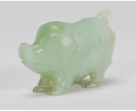 A Chinese jade carved figurine in the form of a stylised pig raised on all four legs looking upward. Measures 4 x 6cm.&nbsp;