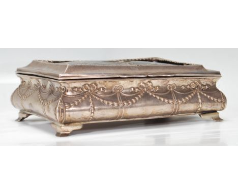 An early 20th Century Edwardian silver hallmarked and tortoiseshell cigarette box raised on silver bracket feet. The body hav