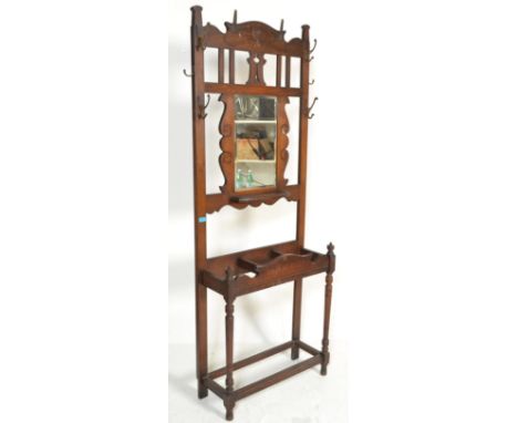 An early 20th Century circa 1920's oak hall stand having a central mirror panel surrounded by brass hooks over three section 