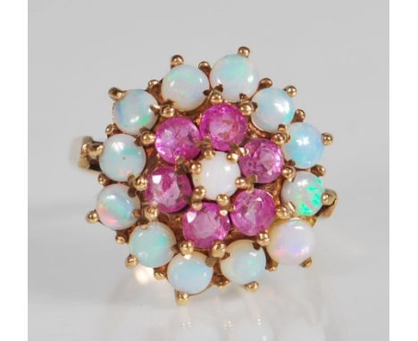 A hallmarked 9ct gold ruby and opal cluster ring. The ring being set with a central opal surrounded by a halo of round mixed 