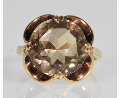 A hallmarked 9ct yellow gold ring having a decorative scroll mount set with a large central round faceted cut quartz stone. H