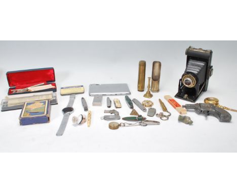 A collection of miscellaneous items to include a folding Kodak camera, trench art shell lighter, playing cards, watches, pota