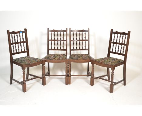 An Ercol beech and elm refectory dining table and chairs suite. The rectangular dining table raised on lyre supports with peg