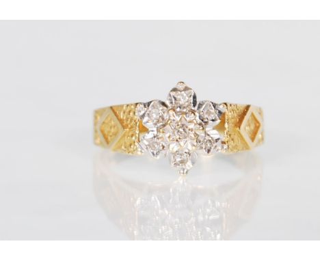 A hallmarked 18ct gold ladies dress ring having geometric engraved shoulders with a white gold faceted flower head mount set 