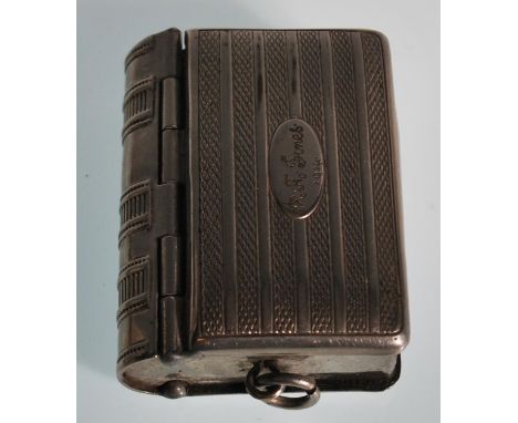 A vintage silver white metal vesta / sovereign case in the form of a book. The spring hinged front opens to reveal a sovereig