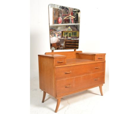 A retro mid 20th Century light oak dressing table chest having a central tapering mirror with two short drawers above two lon