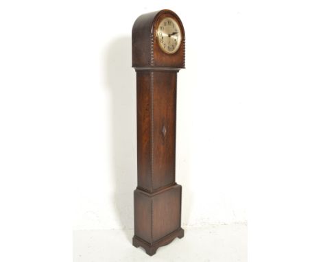 A 1930's Art Deco oak cased grandmother clock, the oak trunk with dome top over silvered dial and faceted hands having an ins