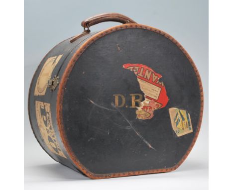 A vintage mid century ladies travelling hat box case with studded leather edgings on black canvas having leather carry handle