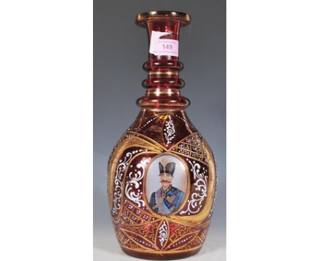A vintage 20th Century Cranberry glass Bohemian style decanter decorated with three panels of a military gentleman in period 