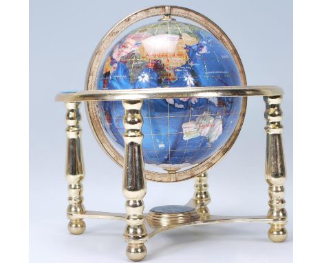 A vintage 20th Century desk top globe having a pearlescent finish, within a brass gimbal with compass to the base. Measures 2