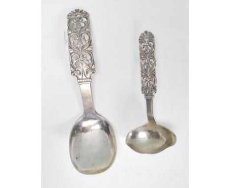 A 20th Century silver serving spoon having scrolled and pierced foliate decoration and a feeding spoon of the same design. St