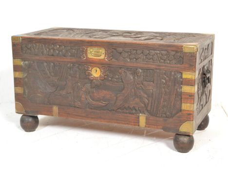 A mid century Chinese camphor wood blanket box trunk. Of rectangular form with brass bound corner edges. Each panel carved in