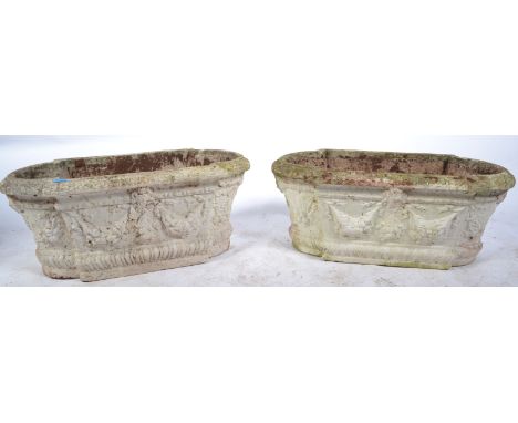 A pair of good 20th Century reconstituted well weathered stone garden planter troughs, cast in relief with swag floral sprays