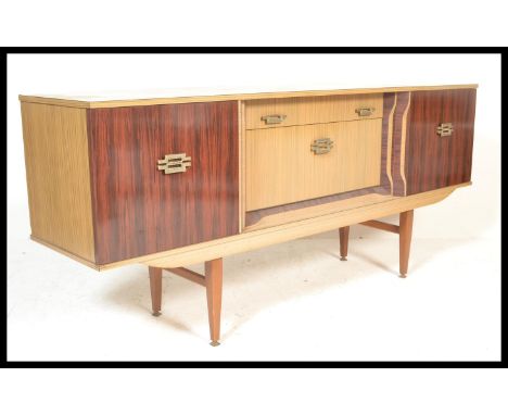 A vintage retro 20th Century two tone melamine sideboard / credenza, central bank of drawers flanked by cupboards raised on t