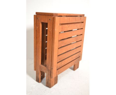 A small folding / gate leg teak wood garden table opening in to rectangular form. Measures 73cm high x 63cm wide x 21cm deep.