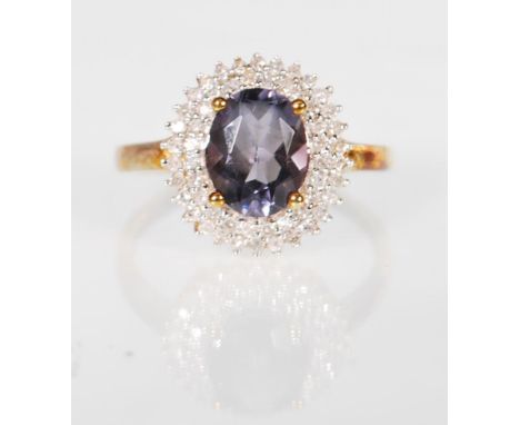 A 9ct gold hallmarked blueberry quartz and diamond cluster dress ring having a central cabochon cut blueberry quartz stone su