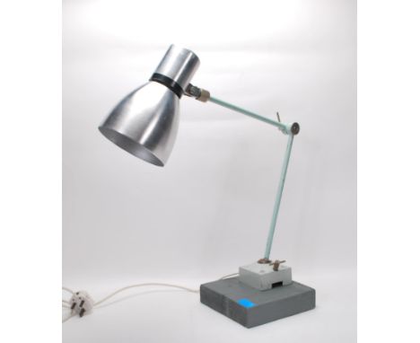 A vintage retro 20th Century industrial work desk lamp raised on a wooden plinth base attached by a square metal base having 