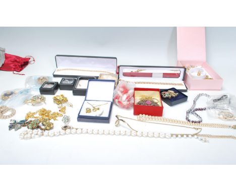 A collection of vintage costume jewellery to include a selection of mid Century brooches, a selection of boxed gold tone tenn