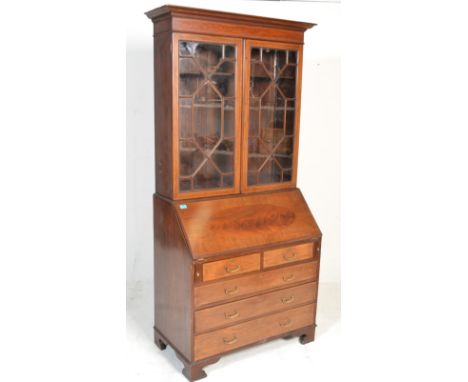 An Edwardian mahogany inlaid bureau bookcase raised on bracket feet with chest under bureau. Above an astragal twin glazed bo