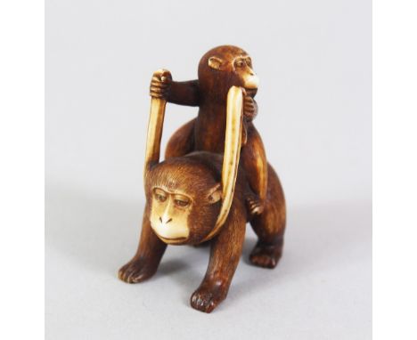 A JAPANESE MEIJI PERIOD CARVED IVORY NETSUKE OF TWO MONKEYS, the young monkey riding upon the back of the adult monkey, himot