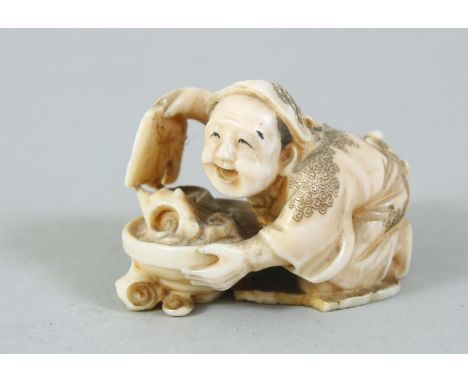 A JAPANESE MEIJI PERIOD CARVED IVORY NETSUKE OF SHELL COLLECTOR, the man crouched over his pan of shells, himotoshi formed to