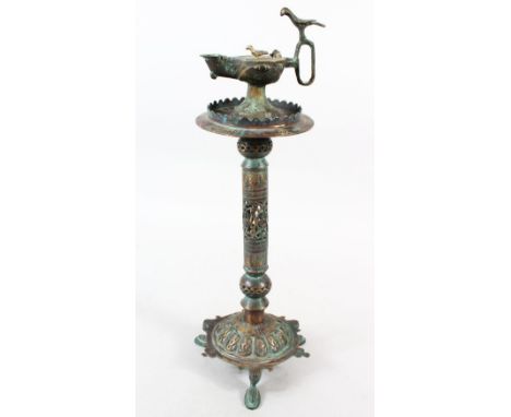 A 13TH CENTURY ISLAMIC BRONZE LAMP, the top with an Aladdin type lamp, 45cm high.