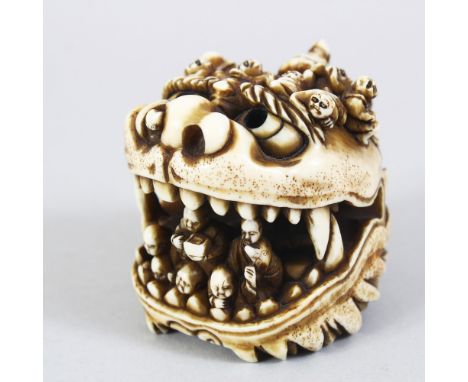 A JAPANESE MEIJI PERIOD CARVED IVORY OKIMONO / NETSUKE OF A SHI SHI DOG, the large model dog with its mouth open, inside the 