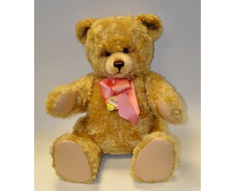 A large Steiff Jackie bear, shaved muzzle, horizontal stitched nose, jointed, felt pads, wearing a pink bow, 73cm high, stud 