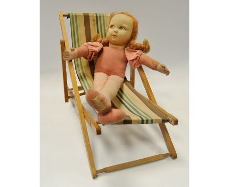 A Norah Wellings felt doll, with light brown plaited hair, brown eyes, 44cm high, label o foot;   a doll deck chair (2)