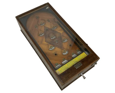 Early 20th century table top bagatelle game 'Uneda', in oak case with glazed top and coin operated mechanism, figured inlaid 