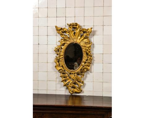 Full title: A richly carved gilt wooden Rococo mirror, 18th C.Description:101 x 55 cmAbout this sale: Paul De Grande is one o