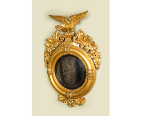 Full title: An impressive gilt wooden eagle-topped mirror with ebonised inner medallion, 19th C.Description:130 x 90 cmAbout 