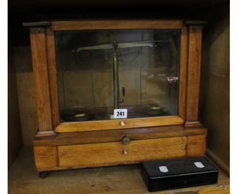 A mahogany cased chemist scale and a box of brass weights