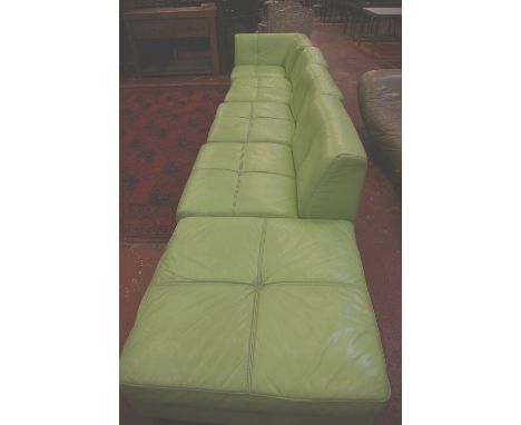 A modern lime green sectional leather sofa and pouffe