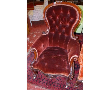 A Victorian button back upholstered and carved walnut chair