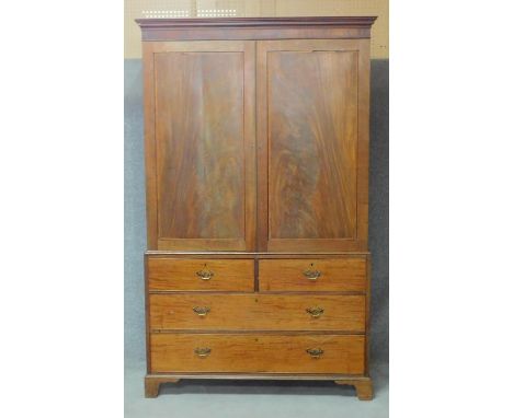 A 19th century flame mahogany linen press with fielded panel doors above two short and two long drawers raised on bracket fee