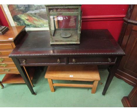 An Edwardian mahogany writing table with beaded edge decoration over two frieze drawers on square tapering legs and ceramic c