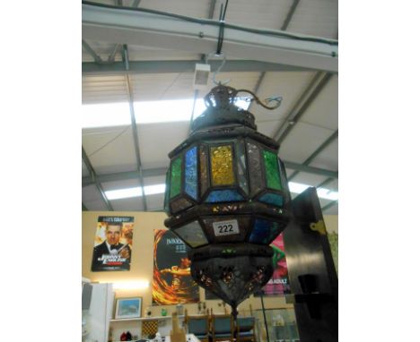 A steel lantern with coloured glass panels