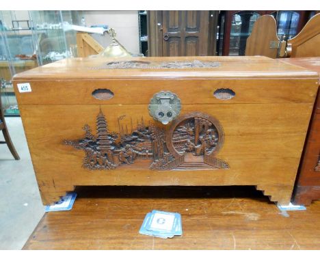 A good early 20th C Camphor wood trunk with heavy carved ornamental scenes