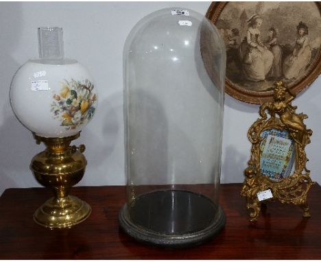 A 19th Century Glass Dome along with an Oil Lamp and a Rococo Style Brass Frame.
