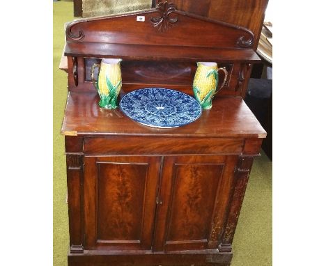 An Early 19th Century Mahogany Chiffonier; with carved crest above a shelf, the base with a frieze drawer above two panel doo