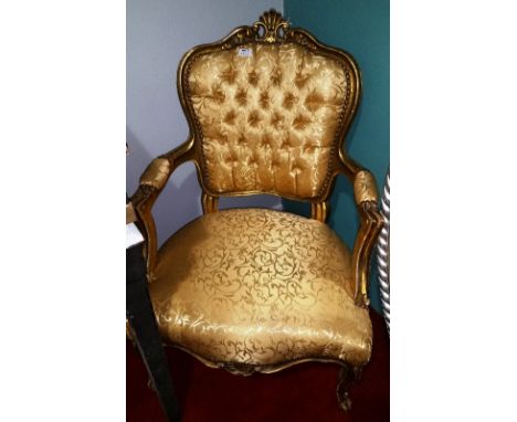 A Continental Gilt and Upholstered Armchair, having a  foliate carved and scroll top rail above a button upholstered back and