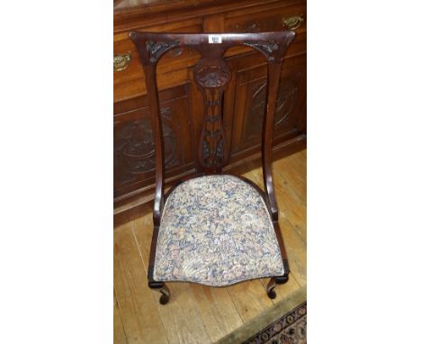 A 19th Century Mahogany Nursing Chair; the stuffed seat upholstered in floral patterned tapestry and standing on cabriole sup