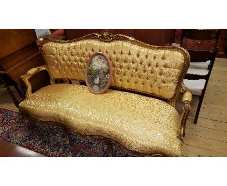 A Continental Gilt and Upholstered Settee, having a serpentine rail with shell cresting above a button upholstered back and s